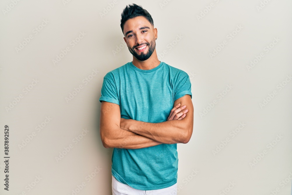 Young man with beard wearing casual clothes happy face smiling with crossed arms looking at the camera. positive person.