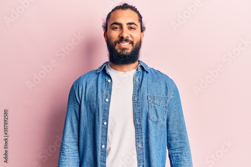 Young arab man wearing casual clothes with a happy and cool smile on face. lucky person.