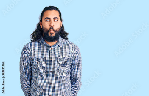 Young arab man wearing casual clothes making fish face with lips, crazy and comical gesture. funny expression.