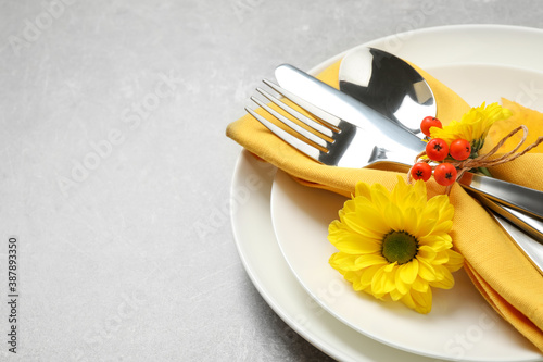 Closeup view of seasonal table setting with autumn flowers and ashberries on light grey background  space for text. Thanksgiving Day