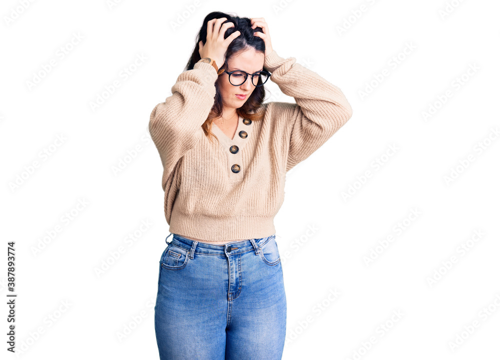 Beautiful young brunette woman wearing casual clothes and glasses suffering from headache desperate and stressed because pain and migraine. hands on head. Beautiful young brunette woman wearing casual clothes and glasses suffering from headache desperate and stressed because pain and migraine. hands on head.