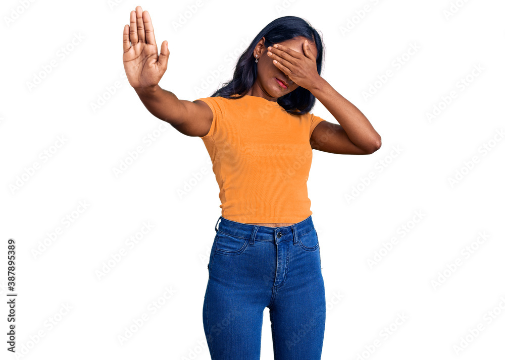 Young indian girl wearing casual clothes and glasses covering eyes with hands and doing stop gesture with sad and fear expression. embarrassed and negative concept. Young indian girl wearing casual clothes and glasses covering eyes with hands and doing stop gesture with sad and fear expression. embarrassed and negative concept.