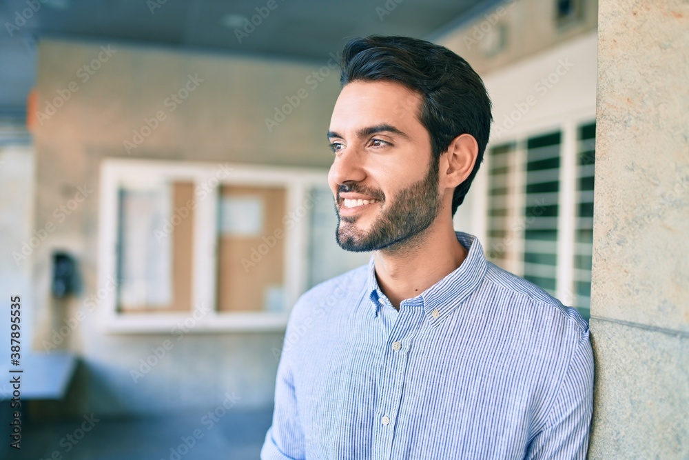 Young hispanic man smiling happy leaning on the wall at the city. Young hispanic man smiling happy leaning on the wall at the city.