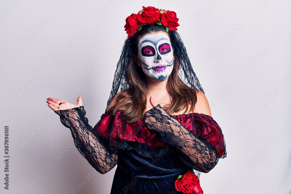 Young woman wearing day of the dead costume over white showing palm hand and doing ok gesture with thumbs up, smiling happy and cheerful