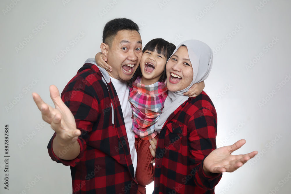 Happy Asian muslim family, father mother and baby girl daughter looking at camera and smiling with greeting gesture Happy Asian muslim family, father mother and baby girl daughter looking at camera and smiling with greeting gesture