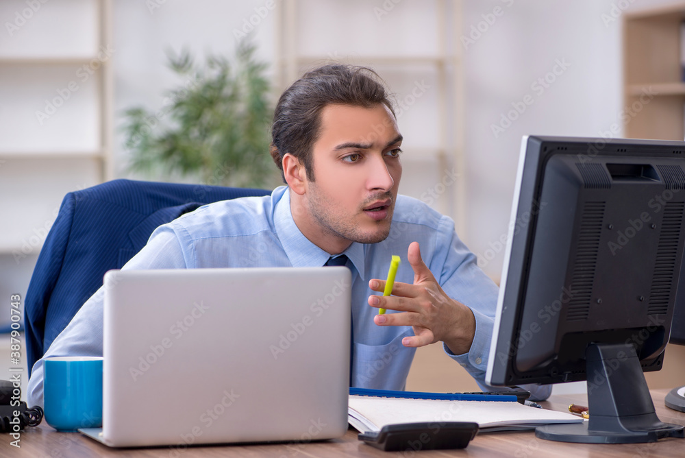 Young male employee working in the office Young male employee working in the office