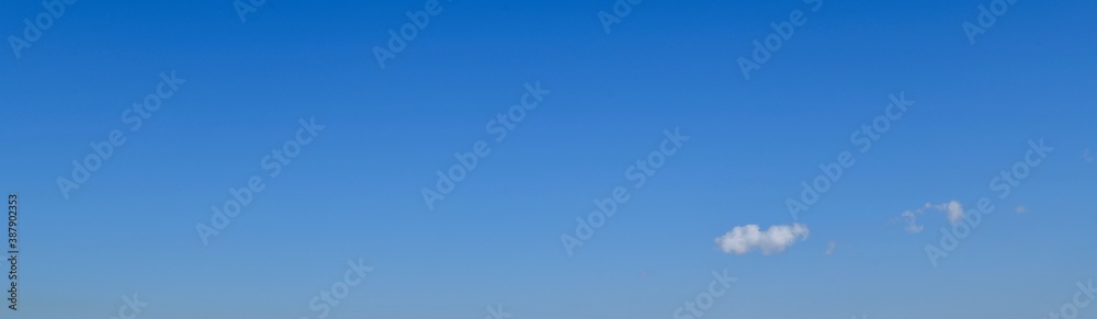 Panoramic image of the blue sky and a light white cloud.