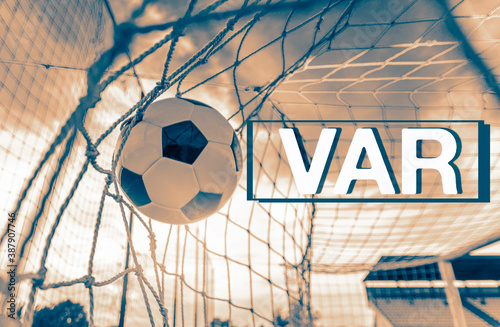 VAR video assistant referee concept, ball going into the back of the net. Soft focus on ball, motion blur 
