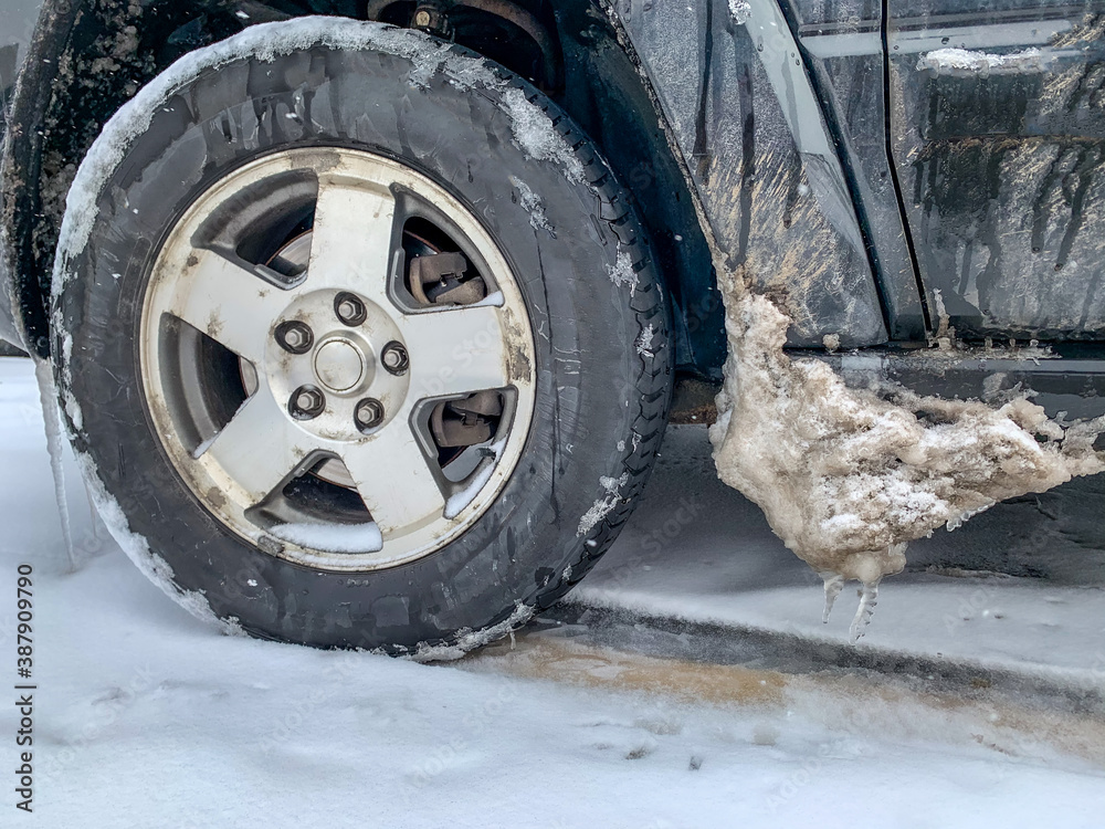 Snow and ice buildup on vehicle next to tire well Snow and ice buildup on vehicle next to tire well