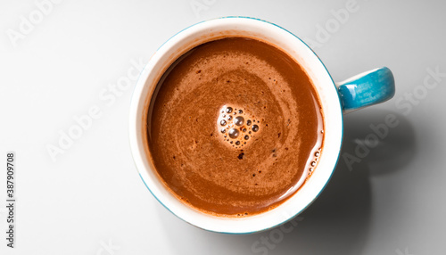 Top view Coffee in blue cup gray table with morning light. Warm tone.