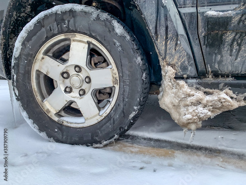 Snow and ice buildup on vehicle next to tire well