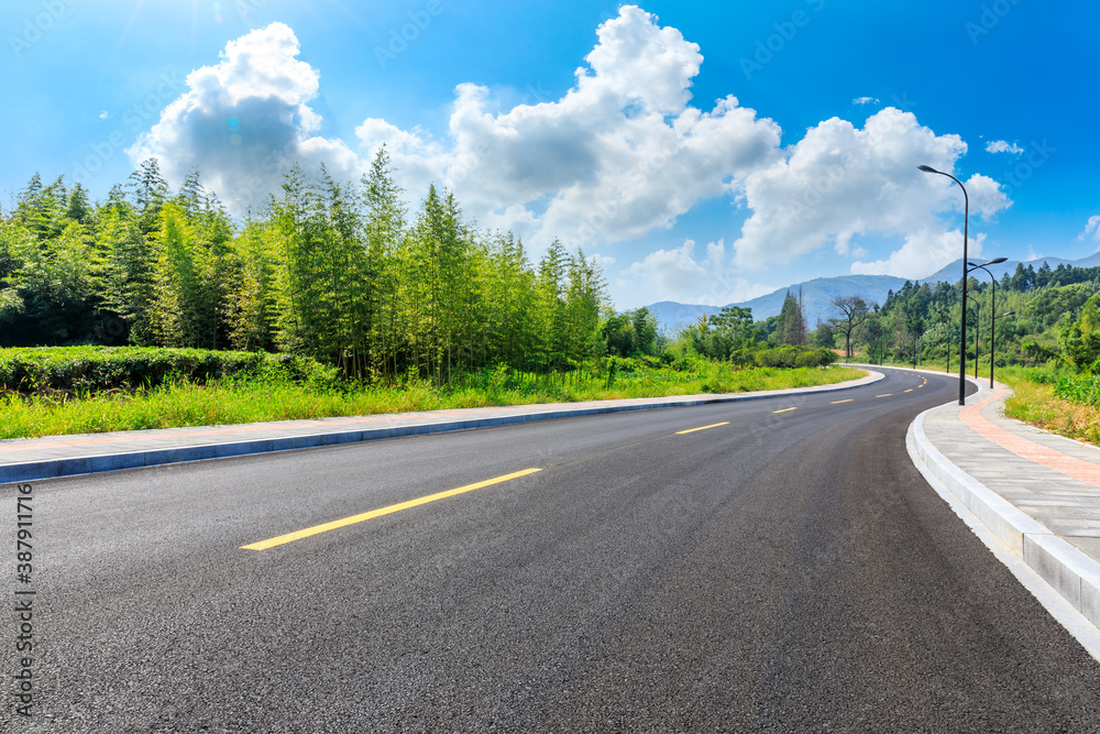 Countryside asphalt road and green plants with mountain natural scenery in Hangzhou on a sunny day.