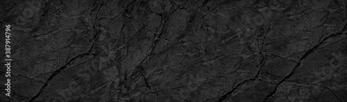 Black white background. Black rock texture with veins and cracks. Marble effect. Stone wall background. Dark gray rough background.