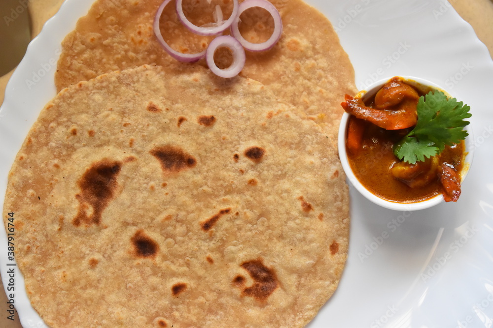 a plate of indian flat bread called as chappati with prawn curry and onion rings a plate of indian flat bread called as chappati with prawn curry and onion rings