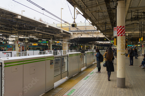 people standing on the platform of train station in Tokyo, Japan 