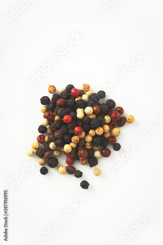 A handful of different types of pepper isolated on a white background. 