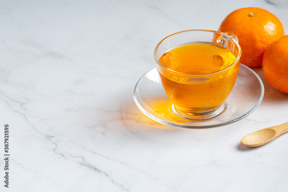 Hot orange tea and fresh orange on the table Hot orange tea and fresh orange on the table
