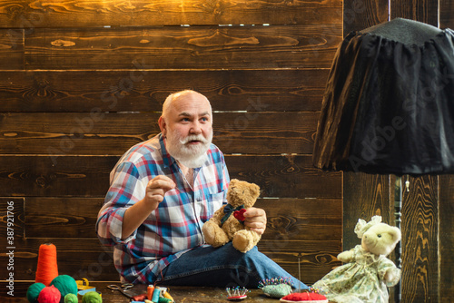 Pensioner sews teddy. Senior handmade toy using needle at home. Retirement Plan and Pension. Sew toys.