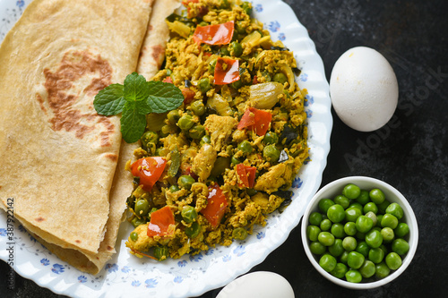 Spicy egg bhurji with Chapati ,Roti, Scrambled egg with Indian flatbread paratha , green peas lentil, protein rich breakfast food Delhi India. Masala egg curry omelette side dish Revoltillo de Huevos photo