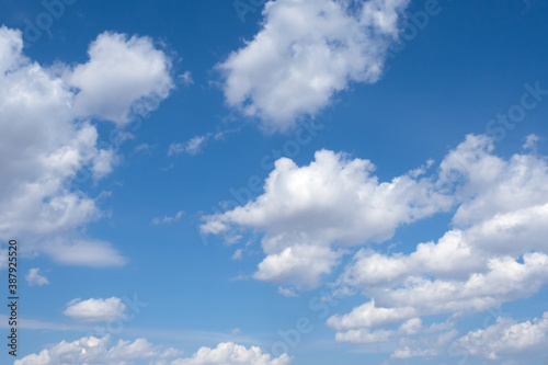 White fluffy cumulus clouds against a blue sky. Summer abstract landscape.