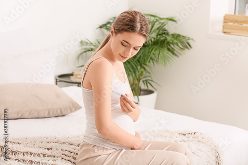 Pregnant diabetic woman giving herself insulin injection at home