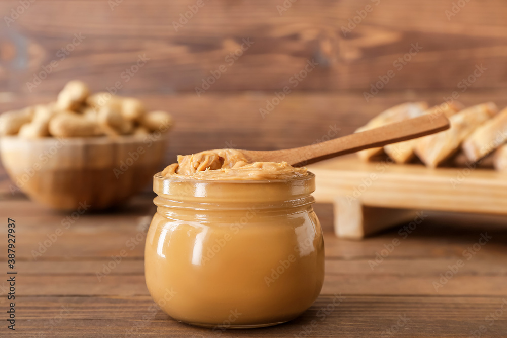 Jar with tasty peanut butter on table Jar with tasty peanut butter on table