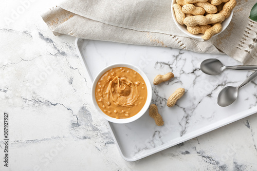 Composition with tasty peanut butter on light background