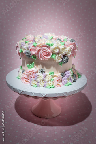 Floral frosted layer cake on pink background