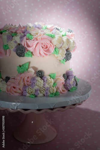 Floral frosted layer cake on pink background