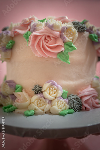 Floral frosted layer cake on pink background