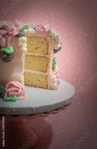 Floral frosted layer cake on pink background