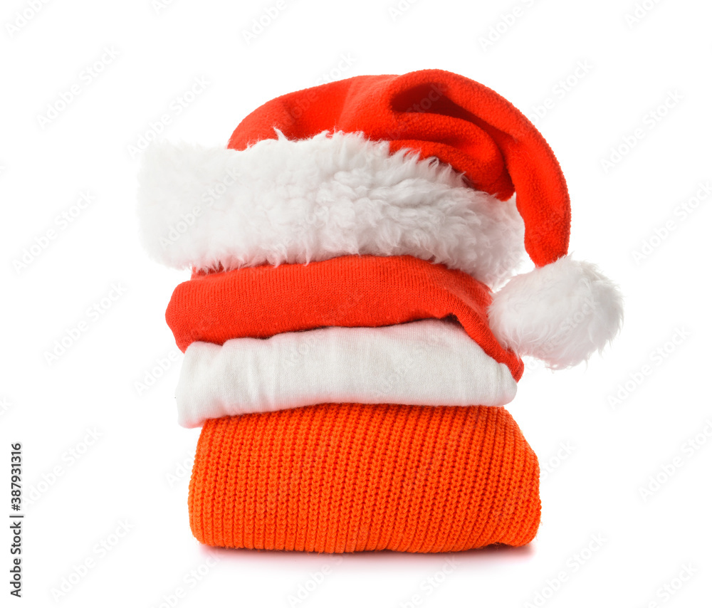 Stylish Christmas clothes with Santa Claus hat on white background Stylish Christmas clothes with Santa Claus hat on white background