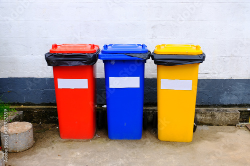 Waste management trash separated by color: red for hazardous waste, blue for general waste and yellow for recyclable waste. © Supratchai
