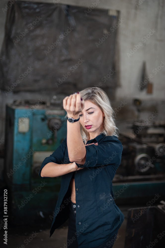 Portrait of a beautiful young blonde woman with blue eyes with old machinery Portrait of a beautiful young blonde woman with blue eyes with old machinery