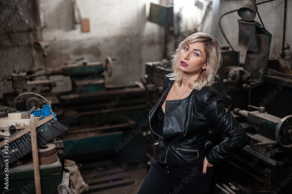 Portrait of a beautiful young blonde woman with blue eyes with old machinery 