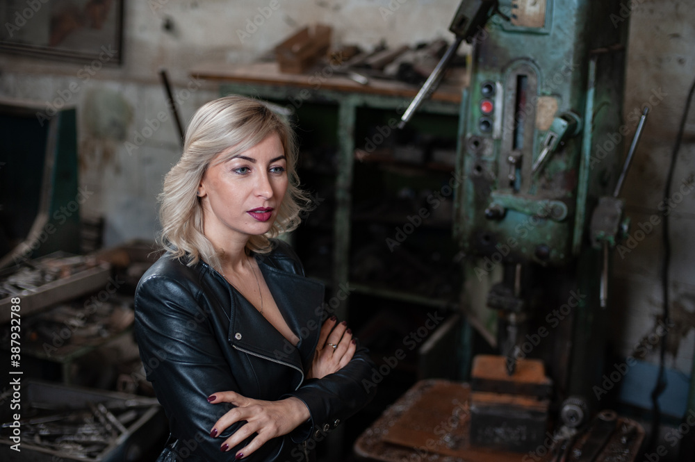 Portrait of a beautiful young blonde woman with blue eyes with old machinery Portrait of a beautiful young blonde woman with blue eyes with old machinery
