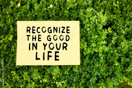 Inspirational quote recognize the good in your life written on paper in a garden with green plants. Gratefulness and thankfulness message concept. © Cagkan