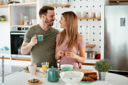 Young couple making sandwich at home. Loving couple enjoying in the kitchen...