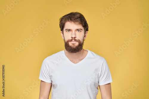 Bearded man on emotions white t-shirt fun lifestyle yellow background