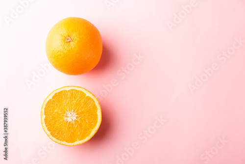 Top view of Fresh half orange fruit slice and full orange in the studio shot isolated on pink background, Healthy food concept