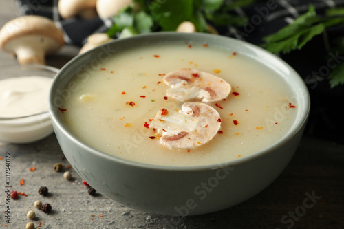 Concept of tasty lunch with bowl of mushroom soup on gray background