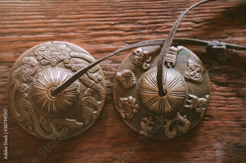 Indian Traditional Musical Instruments for kirtan bronze karatals. object for religious rituals, meditations and alternative medicine. Tibetan temple bells on wooden background photo