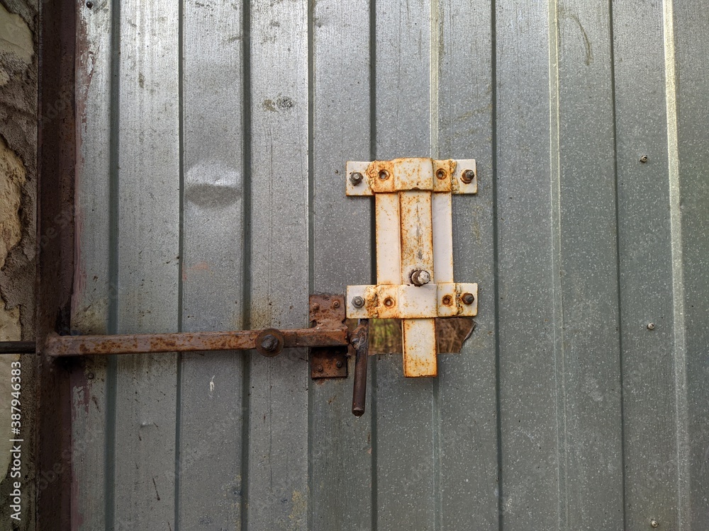 metal and rusty latch lock on a metal fence metal and rusty latch lock on a metal fence