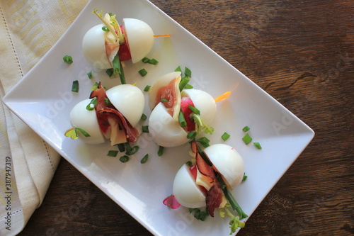 Keto diet. Hard boiled egg, radish , cheese and bacon sandwich on dark background. Easter recipe