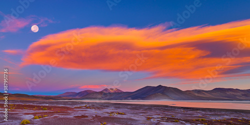 Cloudscape with moon after sunset over volcanoes on the Altiplano of the Andes in the North of Chile