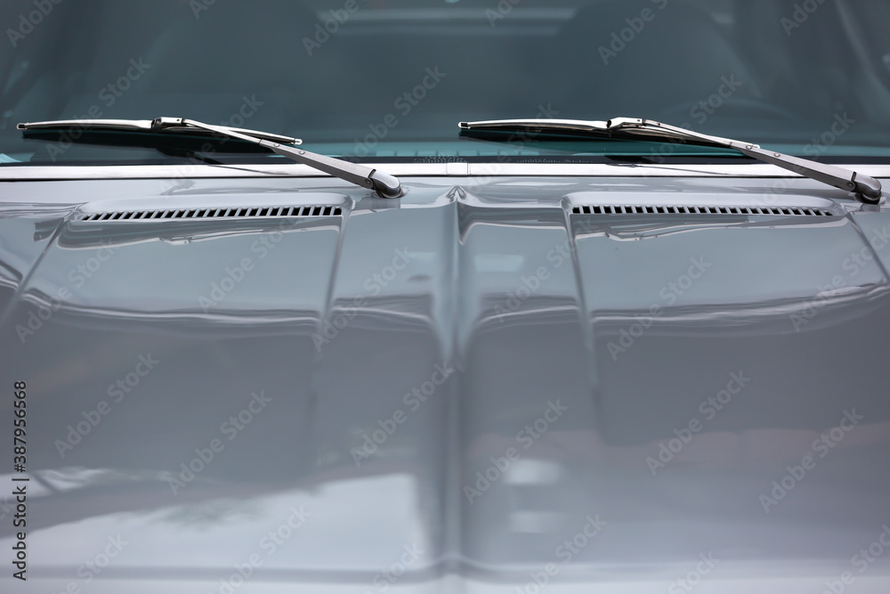 Gray glass windshield and windshield wiper of a classic car