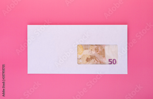 Closed envelope with 50 euro bill inside. International currency and business concept photo