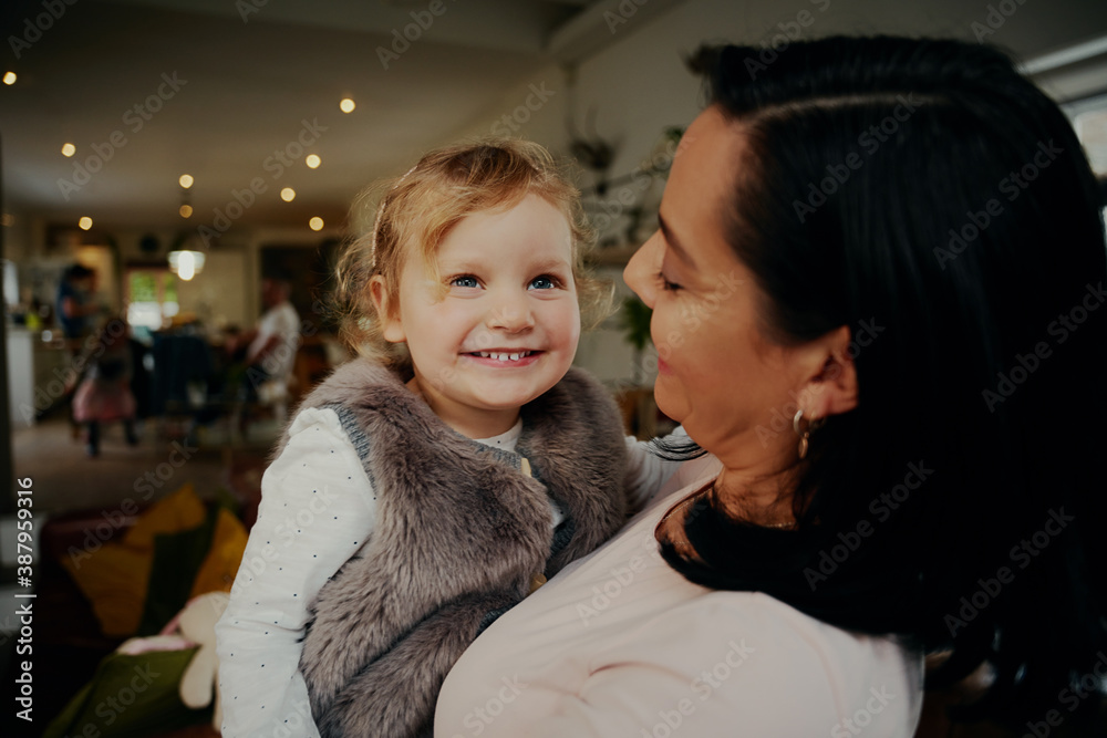 Small preschool cute girl smiling looking at camera on mother hands at home Small preschool cute girl smiling looking at camera on mother hands at home