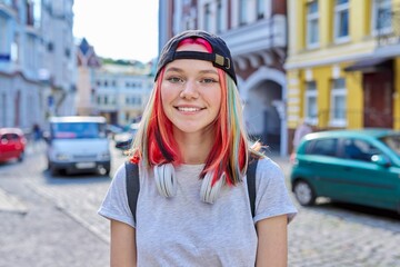 Portrait of fashionable hipster teenage girl with colored dyed hair in black cap