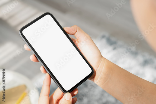 Closeup of woman hand holding smartphone and the screen is blank, social network concept. © sompong